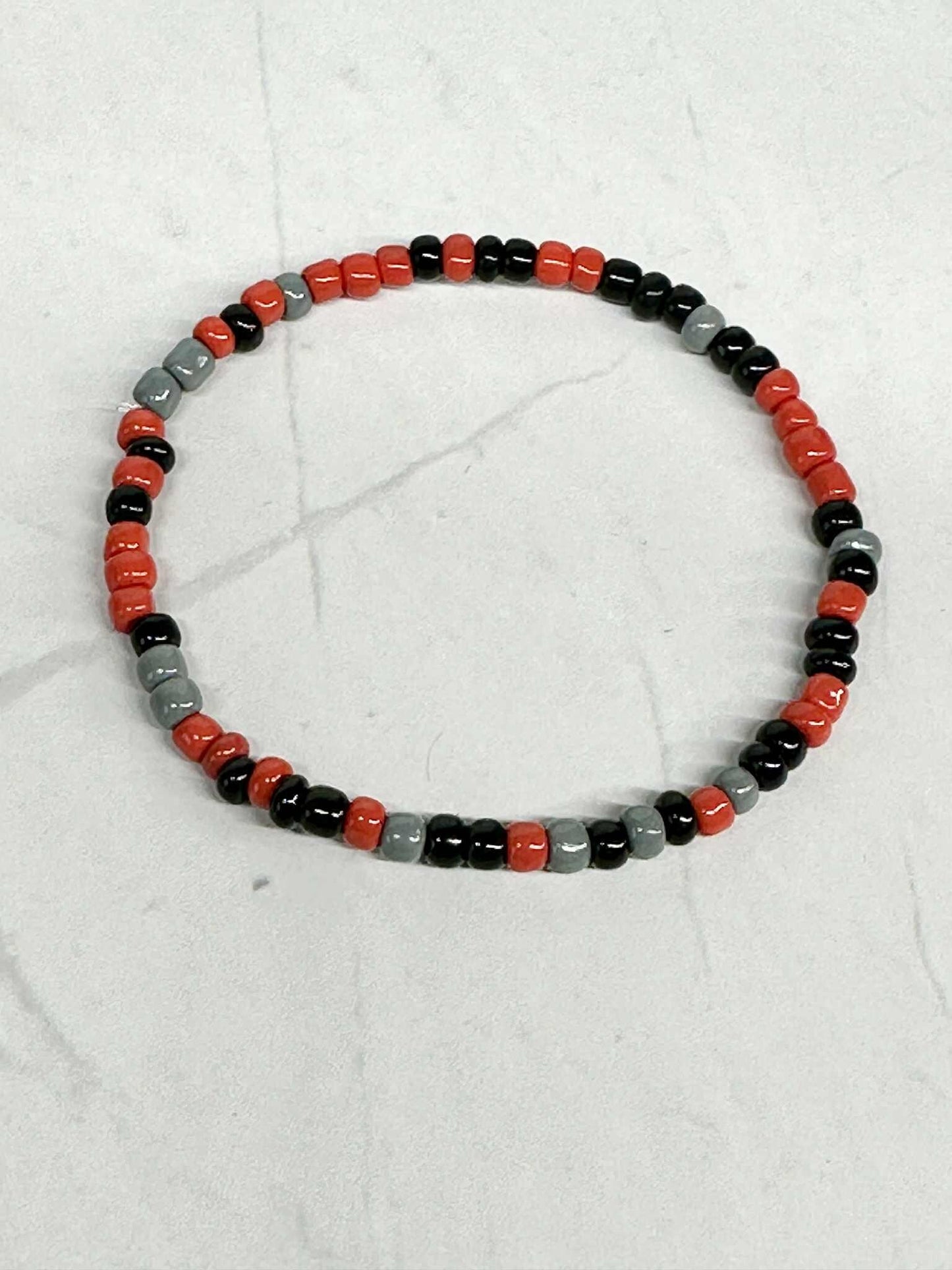 Single Strand Red, Black, and Gray Seed Bead Stretch Bracelet