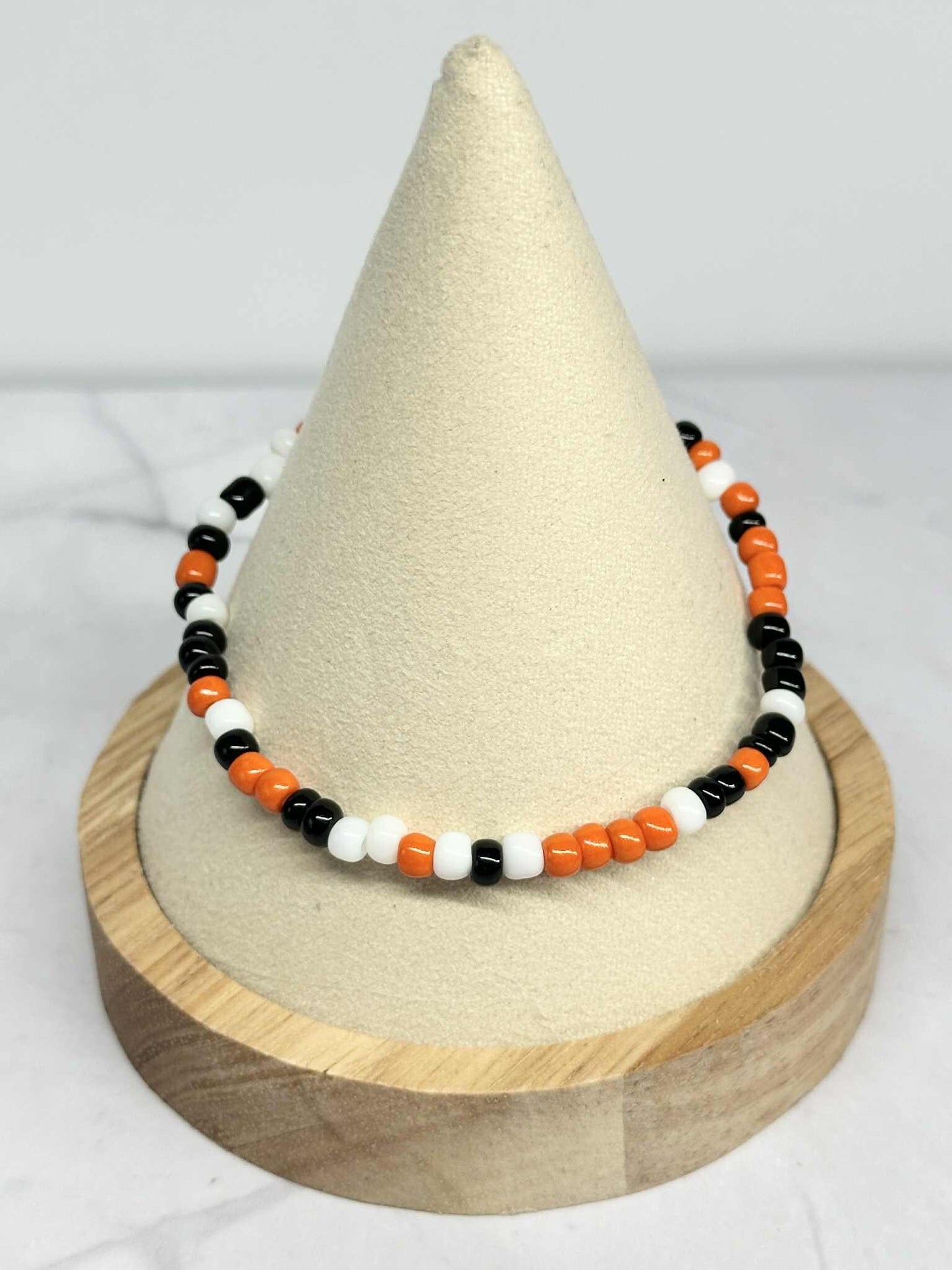 Single Strand Orange, Black and White Seed Bead Stretch Bracelet